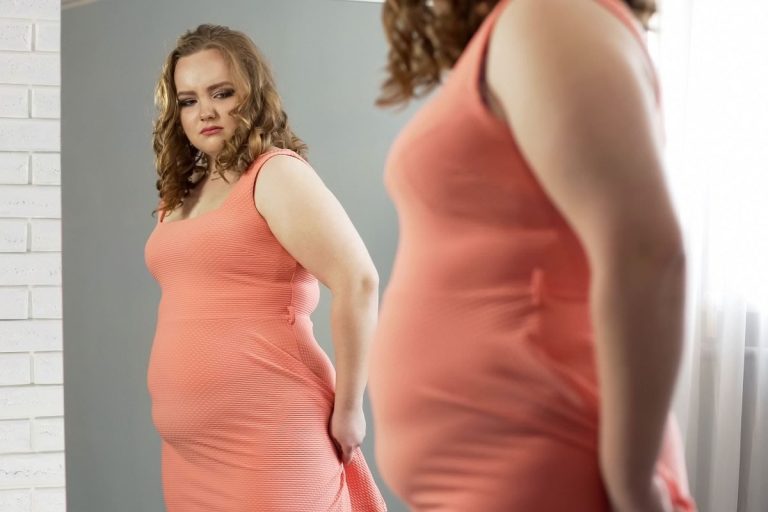 woman with a probleme to hide her belly fat in her tight dress