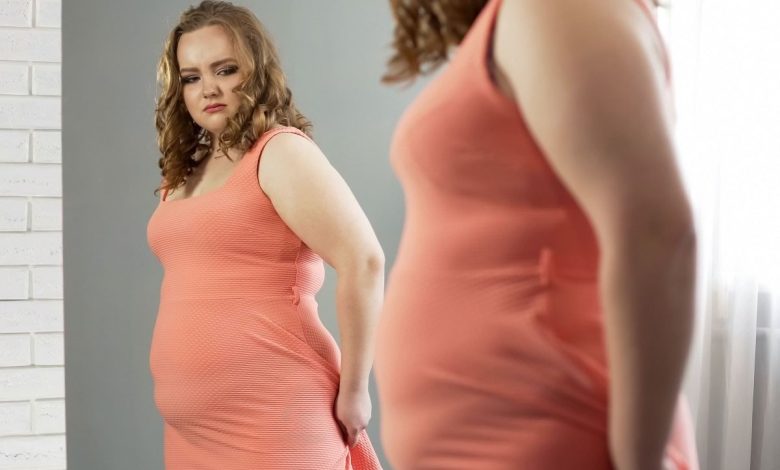 woman with a probleme to hide her belly fat in her tight dress